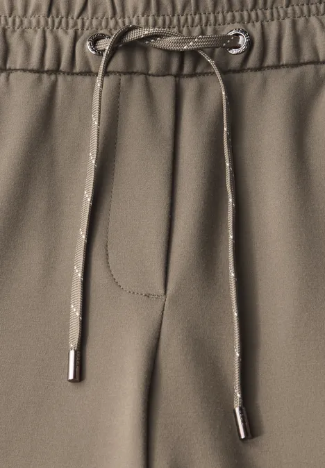 Nahaufnahme einer khakifarbenen Jogginghose mit Kordelzug.